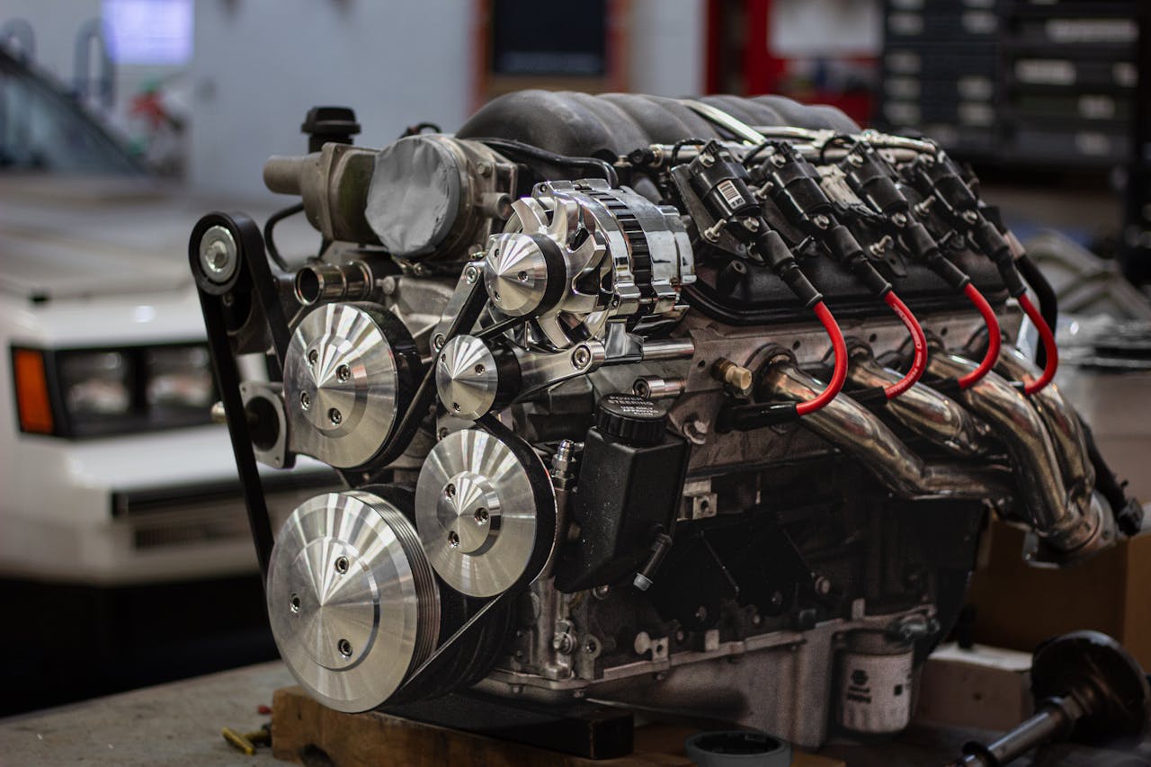 Close-up of an Engine and a Car in the Background in a Garage